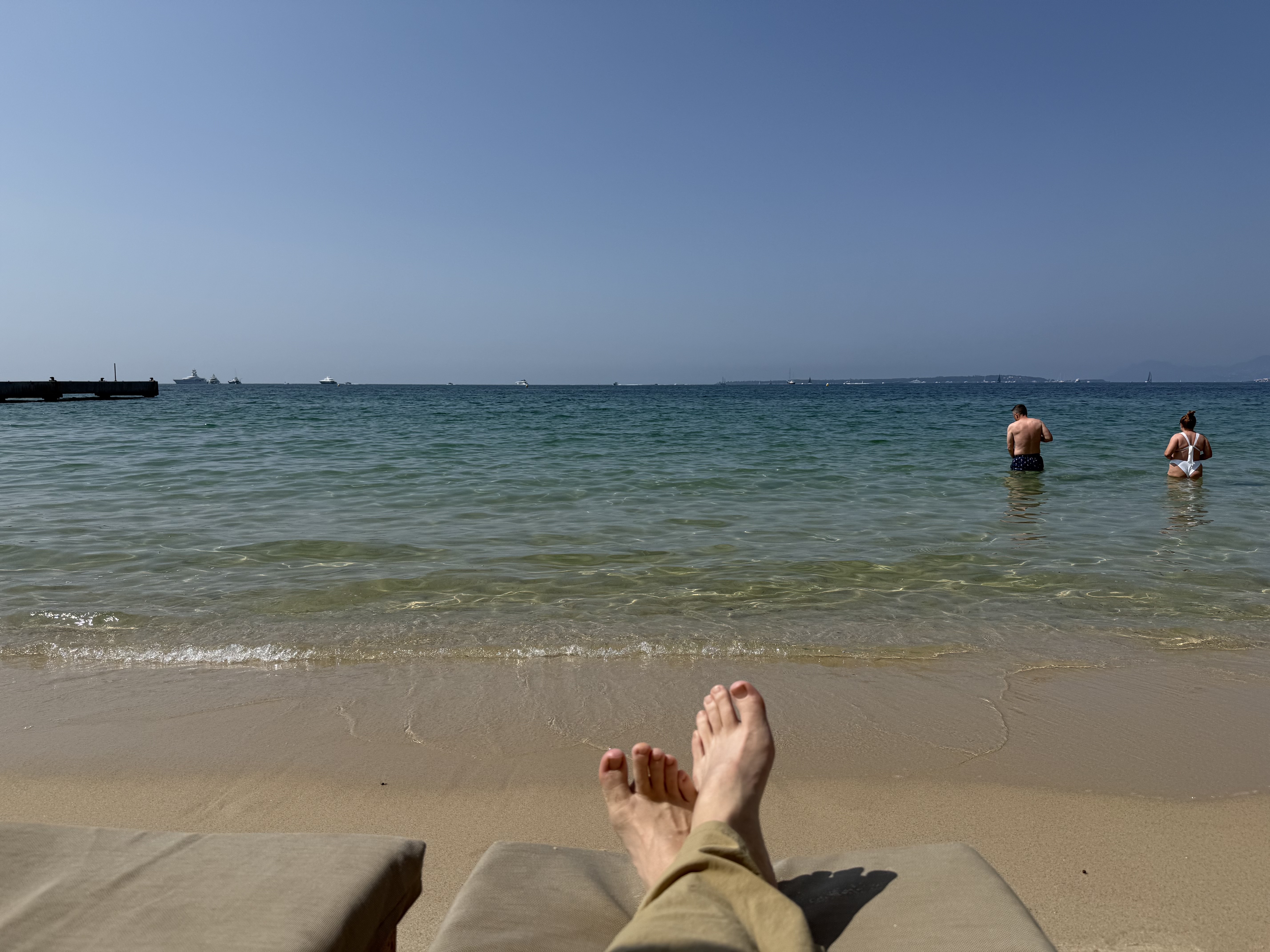 Feet up on sun lounger, turquoise sea